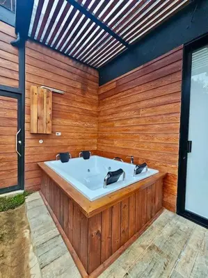 a bathroom with a bath tub in a wooden wall at Montecielo Lodge 41 - Jacuzzi y Vista Piedra Peñol in El Peñol