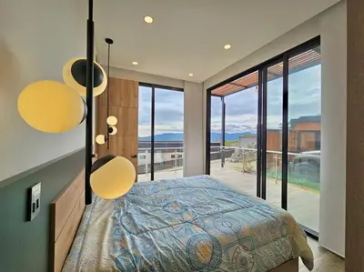 a bedroom with a bed and a large glass window at Montecielo Lodge 41 - Jacuzzi y Vista Piedra Peñol in El Peñol