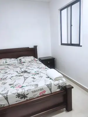 a bedroom with a bed with a phone on it at CASA ESTADIO MEDELLIN Apartamentos Turisticos renovados y modernos cerca al METRO - Barrio Laureles-Estadio in Medellín