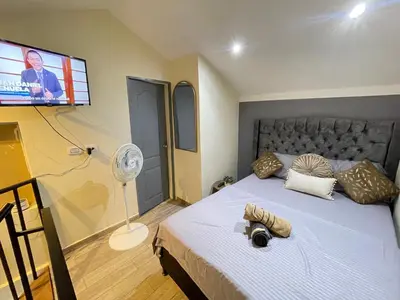 a bedroom with a bed with a tv on the wall at Joes loft la70 laurles estadio Apt de 1Alcoba in Medellín