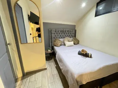 a small bedroom with a bed and a mirror at Joes loft la70 laurles estadio Apt de 1Alcoba in Medellín