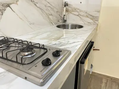 a kitchen counter with a stove and a sink at Joes loft la70 laurles estadio Apt de 1Alcoba in Medellín