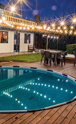 a swimming pool with a picnic table and lights at Hermosa finca con vista a la piedra y embalse de Guatapé, con jacuzzi y piscina in Guatapé