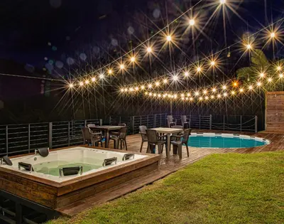 a patio with a hot tub and tables and lights at Hermosa finca con vista a la piedra y embalse de Guatapé, con jacuzzi y piscina in Guatapé