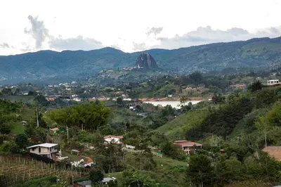 a town on a hill with a river and mountains at Hermosa finca con vista a la piedra y embalse de Guatapé, con jacuzzi y piscina in Guatapé