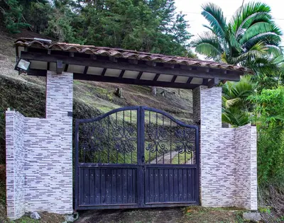 an entrance to a gate with a brick wall at Hermosa finca con vista a la piedra y embalse de Guatapé, con jacuzzi y piscina in Guatapé