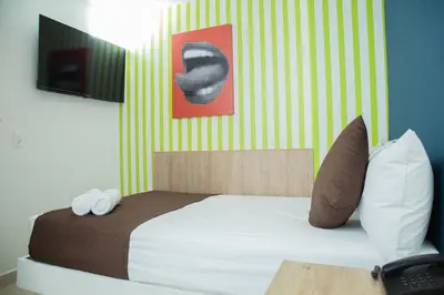 a bed with two pillows and a picture on the wall at Bajo la luna hotel in Medellín