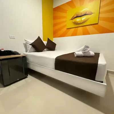 a bedroom with a bed with a painting on the wall at Bajo la luna hotel in Medellín
