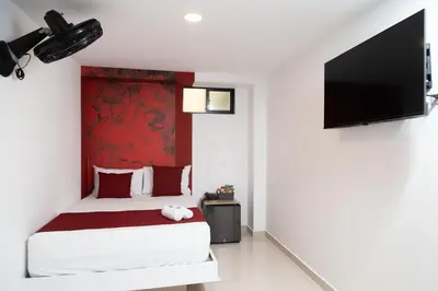 a bedroom with a bed and a flat screen tv at Bajo la luna hotel in Medellín