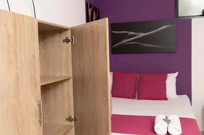 a bedroom with a bed and a purple wall at Bajo la luna hotel in Medellín