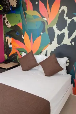 a bed in a room with a colorful wall at Bajo la luna hotel in Medellín