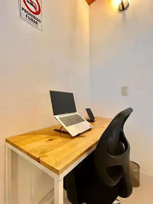 a laptop computer sitting on top of a wooden desk at Apto amplio 3 hab para familias y grupos Sabaneta in Sabaneta