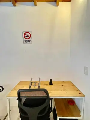 a desk with a chair and a no smoking sign on a wall at Apto amplio 3 hab para familias y grupos Sabaneta in Sabaneta