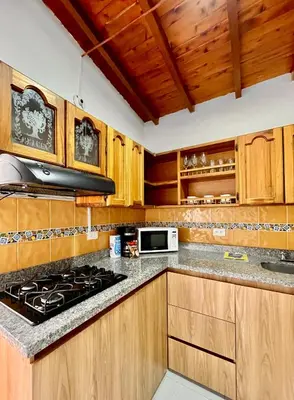 a kitchen with wooden cabinets and a stove top oven at Apto amplio 3 hab para familias y grupos Sabaneta in Sabaneta
