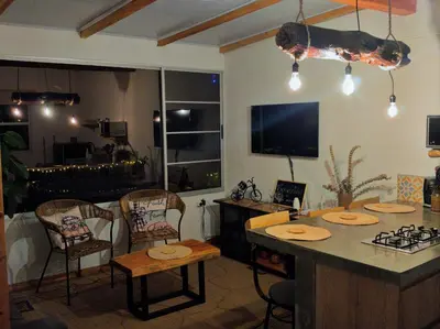 a living room with a kitchen with a table and chairs at Green mount in Medellín
