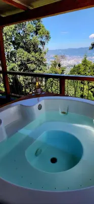 a bath tub sitting on a balcony with a view at Green mount in Medellín