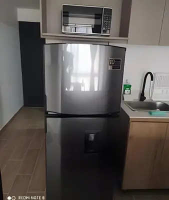 a refrigerator with a microwave on top of it in a kitchen at Metro floresta acogedor apartaestudio in Medellín