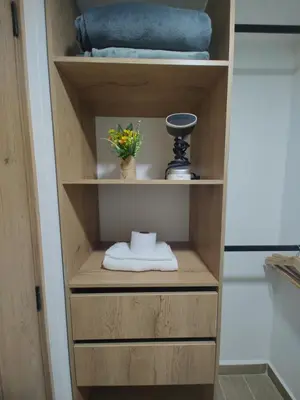 a wooden cabinet with a towel and a vase of flowers at Metro floresta acogedor apartaestudio in Medellín