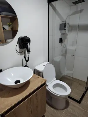 a bathroom with a toilet and a sink and a shower at Metro floresta acogedor apartaestudio in Medellín