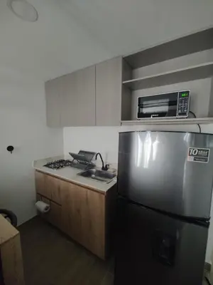 a kitchen with a stainless steel refrigerator and a microwave at Metro floresta acogedor apartaestudio in Medellín