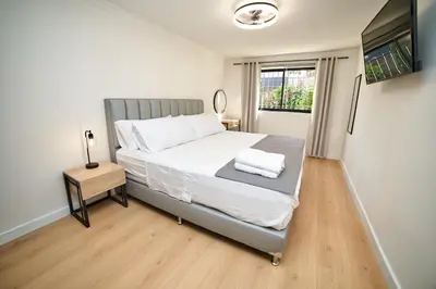 a bedroom with a bed with white sheets and a window at Casa en Laureles- Excelente Ubicación! in Medellín