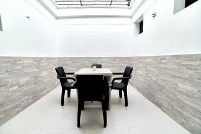 a table and chairs in a room with a brick wall at Casa en Laureles- Excelente Ubicación! in Medellín