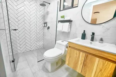 a bathroom with a toilet and a sink and a mirror at Casa en Laureles- Excelente Ubicación! in Medellín