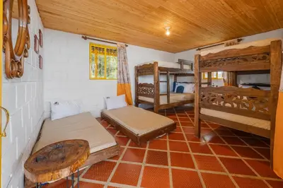 a room with beds and bunk beds in a house at Ecohotel Salma in Villamaría