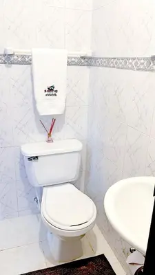 a white bathroom with a toilet and a sink at Ecohotel Salma in Villamaría