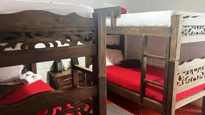 two bunk beds with red sheets in a room at Ecohotel Salma in Villamaría
