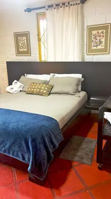 a bedroom with a large bed with a blue blanket on it at Ecohotel Salma in Villamaría