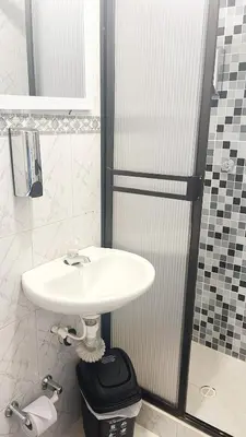 a bathroom with a white sink and a shower at Ecohotel Salma in Villamaría