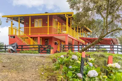 a house with a yellow and red house at Ecohotel Salma in Villamaría