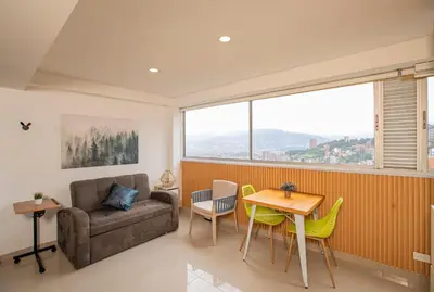 a living room with a couch and a table and chairs at Apto con la mejor vista del Edificio in Medellín