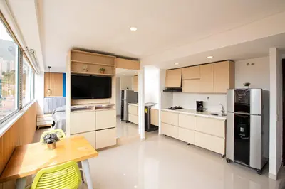 a large kitchen with a table and a refrigerator at Apto con la mejor vista del Edificio in Medellín