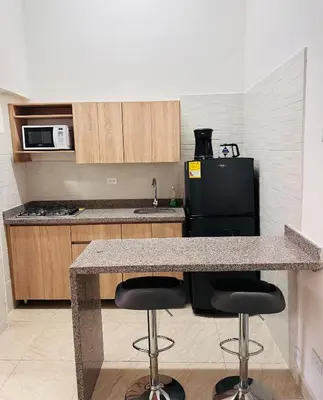 a kitchen with a counter and two bar stools at Apartamento Central La Candelaria Medellín in Medellín