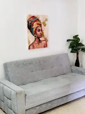 a couch in a living room with a painting on the wall at Apartamento Central La Candelaria Medellín in Medellín