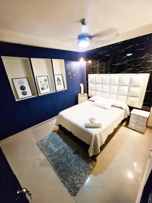 a bedroom with a white bed and a blue wall at 5 Bedrooms Apartment with Jacuzzi at Lleras park in Medellín