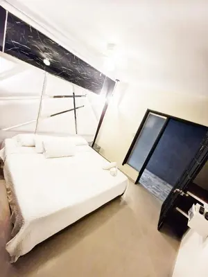 a white bed in a room with a window at 5 Bedrooms Apartment with Jacuzzi at Lleras park in Medellín