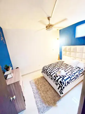 a bedroom with a bed with a black and white comforter at 5 Bedrooms Apartment with Jacuzzi at Lleras park in Medellín