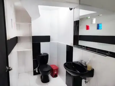 a bathroom with a black toilet and a sink at 5 Bedrooms Apartment with Jacuzzi at Lleras park in Medellín