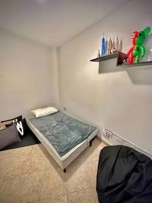 a bedroom with a bed and a shelf on the wall at Colonial Charm House in Medellín