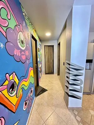 a hallway with a wall with a hello kitty mural at Colonial Charm House in Medellín