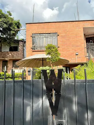 a fence with an umbrella in front of a building at Colonial Charm House in Medellín