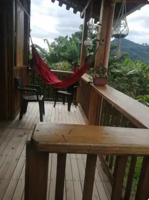 a hammock on the deck of a house at Cabañas Lucerito Colibrí in Jardin