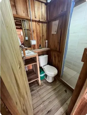 a wooden bathroom with a toilet and a sink at Cabañas Lucerito Colibrí in Jardin