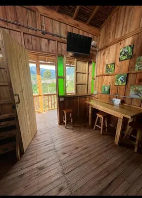 a wooden room with a wooden table and a tv in it at Cabañas Lucerito Colibrí in Jardin