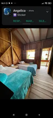 a room with two beds in a wooden house at Cabañas Lucerito Turpial in Jardin