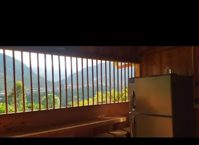 a kitchen with a refrigerator and a window with a view at Cabañas Lucerito Turpial in Jardin