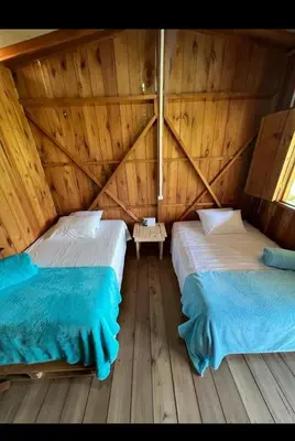 two beds in a room with wooden floors at Cabañas Lucerito Turpial in Jardin